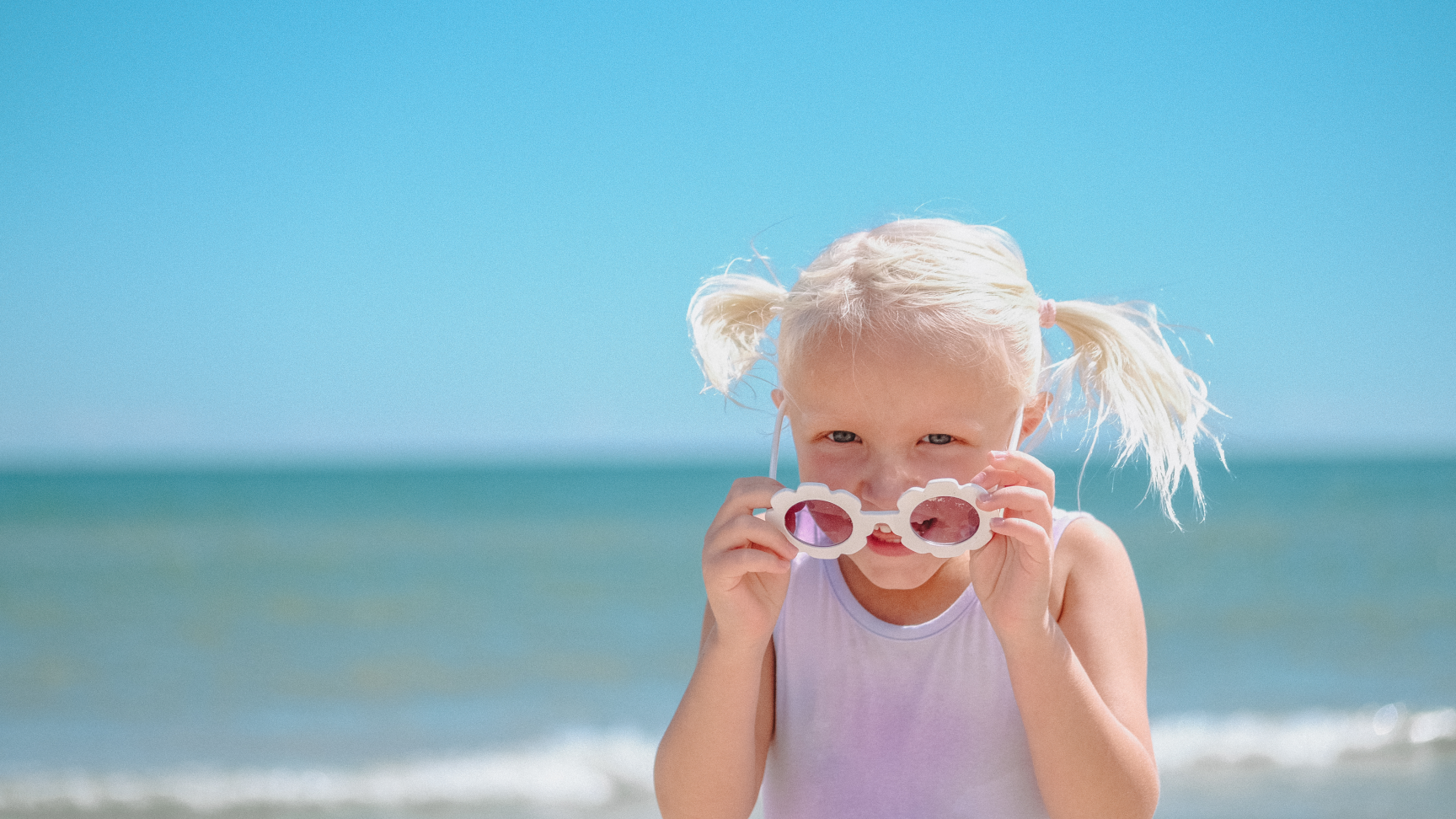 Kind mit Sonnenbrille am Strand 